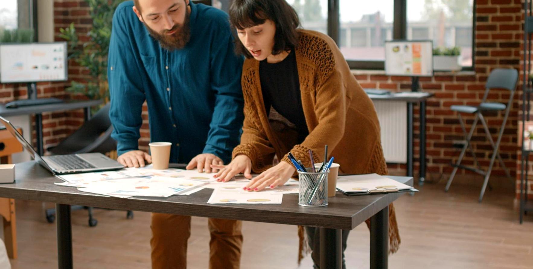 Profesionales trabajando en análisis financiero con documentos y gráficos